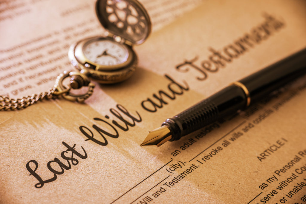 Vintage / retro style with a long shadow : Fountain pen a pocket watch on a last will and testament. A form is printed on a mulberry paper and waiting to be filled and signed by testator / testatrix.