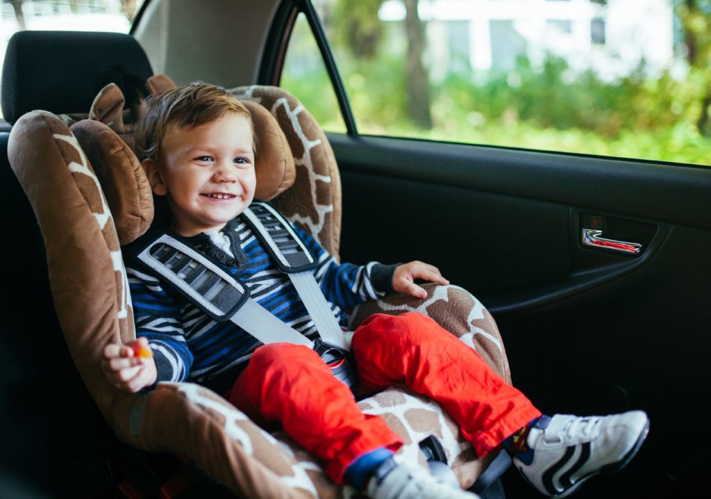 Happy kid sitting in his carseat.