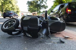 Moped accident happening along the road.