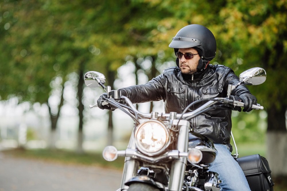 Motorcycle rider wearing helmet and safety gear.