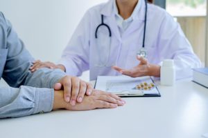 A doctor explains a man's injuries to him.