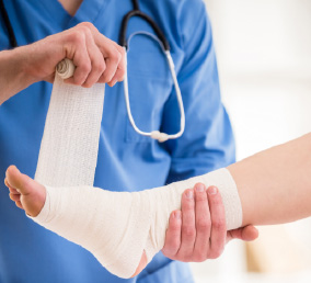 doctor wrapping a patient's ankle