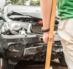 injured car accident victim looking at his car