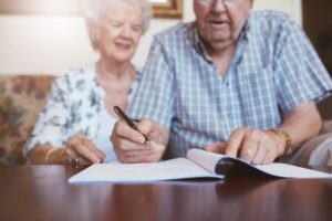 A couple writes their will to give to their wills and trusts attorney.