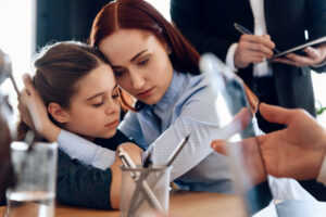 Sad daughter hugging her mom in lawyers office.