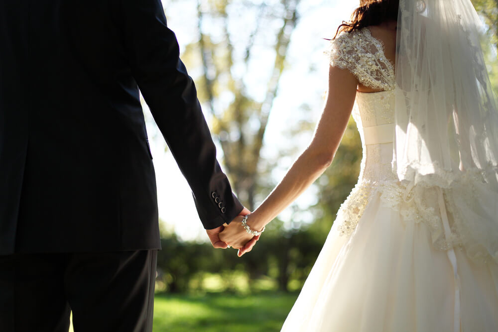 Newly wed couple holding hands.