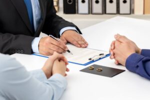 Ex-couple signing divorce papers.