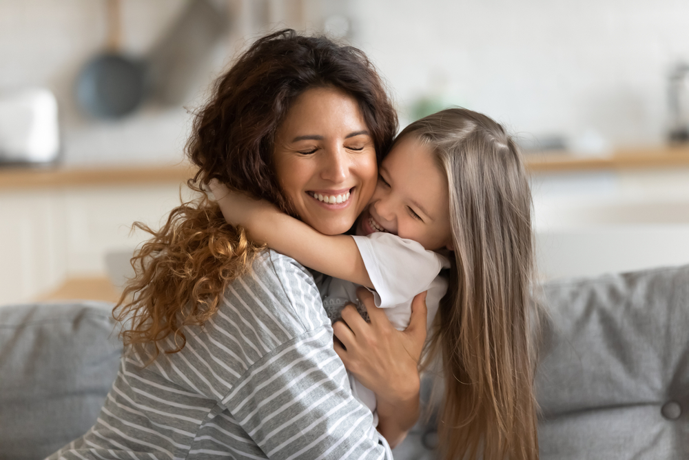 Happy kid hugging her mother.