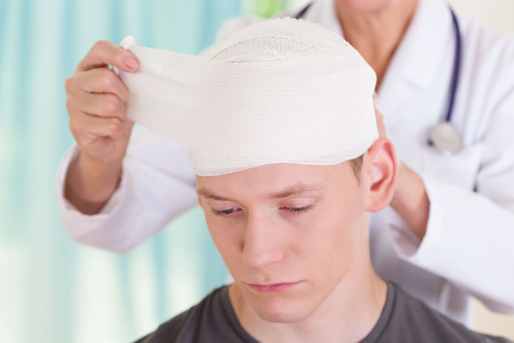 Traumatized patient with head bandage due to accident.