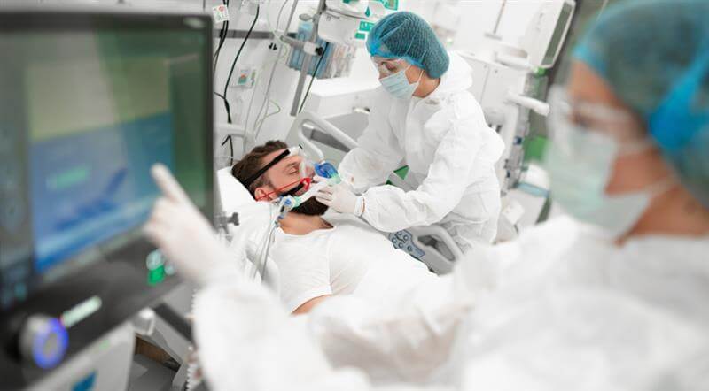 Injured patient in critical condition monitored by healthcare professionals.
