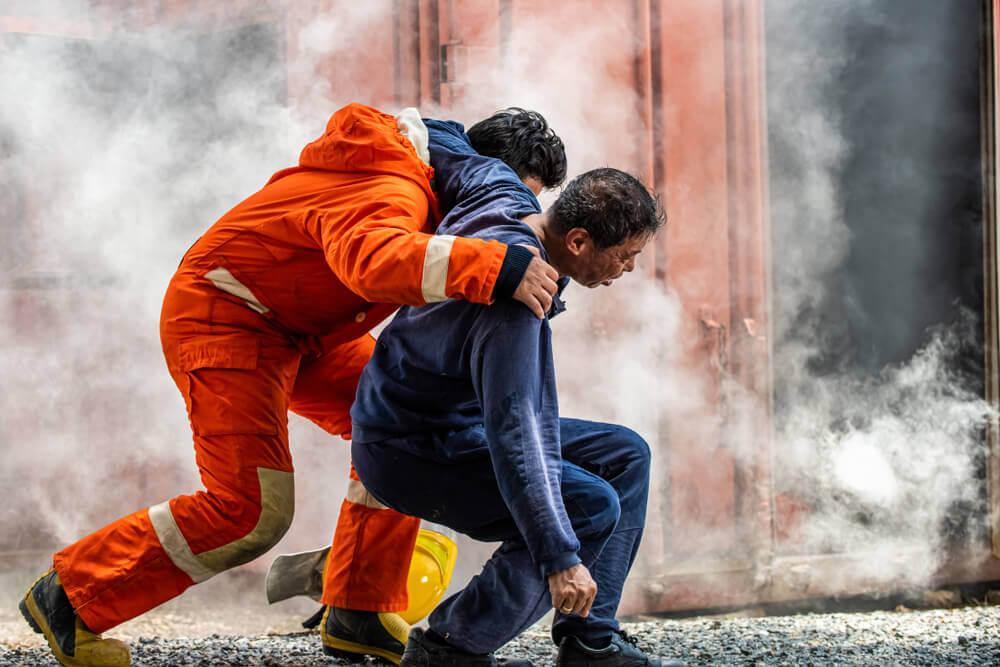 Injured victim rescued from fire burning warehouse.