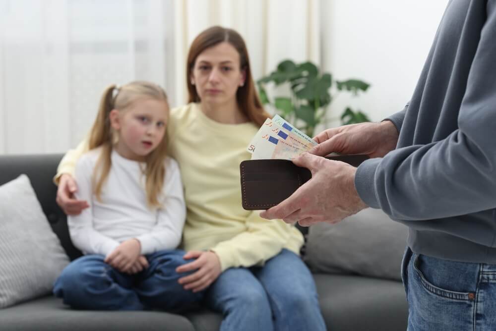 Man giving alimony to his ex-wife and daughter at home.